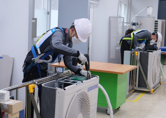 지난 1일 경기도 수원 삼성전자 CS아카데이에서 열린 서비스 기술경진대회에 참가한 엔지니어들이 제품을 수리하고 있다. <삼성전자서비스 제공>